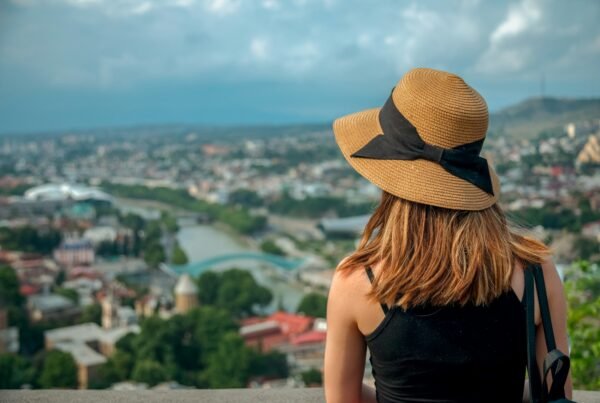 Woman in sun hat looking from panorama at Tbilisi city